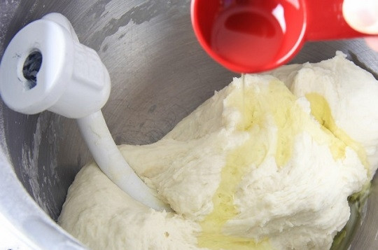 1. Этап. Хачапури по-грузински с сыром: 3. В процессе добавьте воду. В конце влейте растительное масло.