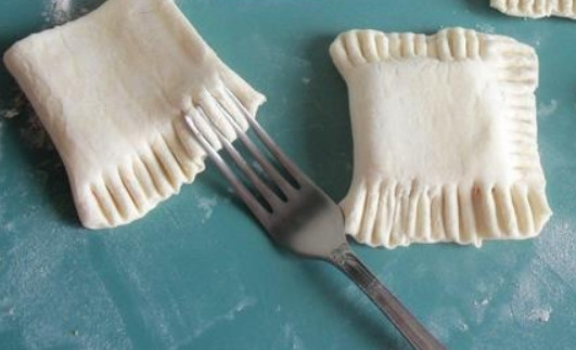 1. Этап. Слойки из готового дрожжевого теста: Сложите прямоугольники теста пополам. Склеиваем края, прижимая их вилкой с двух сторон.