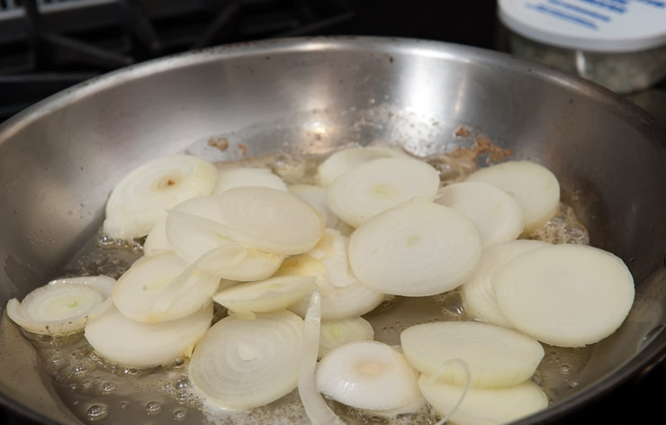 1. Этап. Сэндвичи с мясом: Нарежьте лук и растопите пару столовых ложек сливочного масла в большой сковороде на среднем огне. Потушите лук до золотистого цвета.