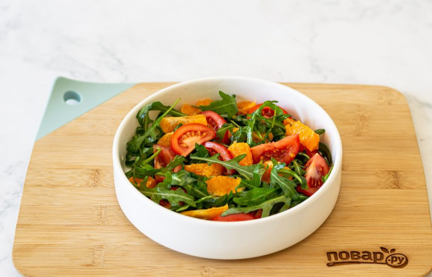 1. Этап. Салат с рукколой и мандаринами: Выложите зелень в глубокую миску. Добавьте помидоры черри, мандарин и тертый сыр пармезан.