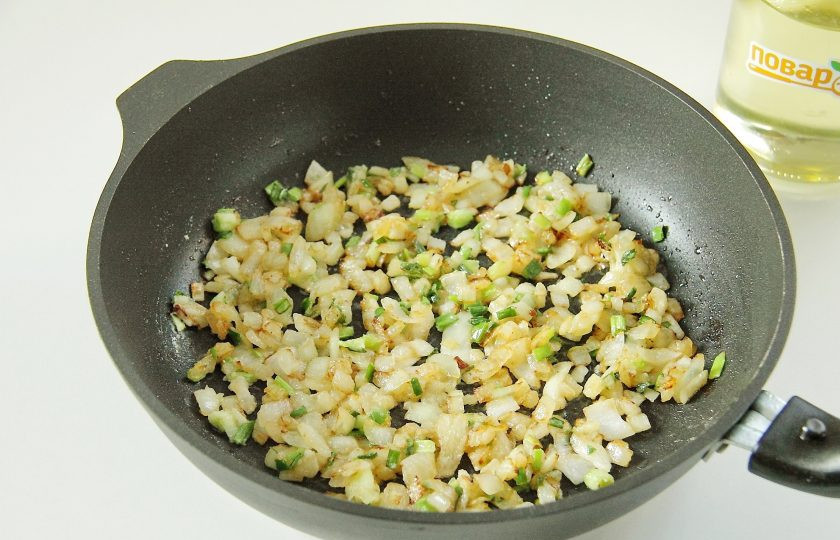 1. Этап. Мясные рулетики с луком: Переложите обжаренные рулетики на тарелку, а на этой же сковороде обжарьте оставшуюся луковицу, нарезанную кубиками. Затем добавьте в сковороду зеленый лук и 1,5 ст. л. муки. Перемешайте и обжарьте все вместе на небольшом огне около минуты.