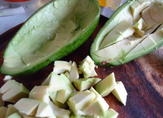 1. Этап. Салат из авокадо с креветками и яйцом: Авокадо порежьте пополам, достаньте косточку. С помощью ножа и ложки аккуратно достаньте мякоть и порежьте ее на кубики.