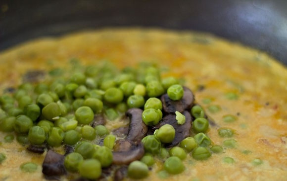 1. Этап. Карри с рисом, горошком и грибами: Добавьте обжаренные грибы и горошек. Хорошо все перемешайте.