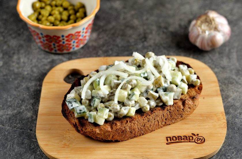1. Этап. Брутальные бутерброды Три огурца: Выложите на каждый ломтик хлеба приготовленную из огурцов начинку, сверху посыпьте свежим сладким луком, нарезанным кольцами или полукольцами. Если будете использовать обычный репчатый лук, тогда сбрызните его 6% уксусом, чтобы убрать горечь.