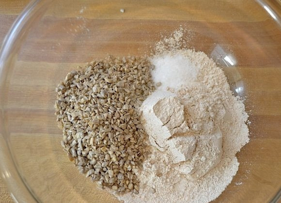 1. Этап. Хлеб с семечками: 3. В миску всыпьте стакан цельнозерновой муки, добавьте к нему семена подсолнуха.