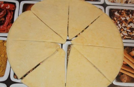 1. Этап. Дрожжевые рогалики: С помощью большого блюда или крышки от кастрюли вырезаем из раскатанного теста круг с ровными краями. Разрезаем его на 8 частей-треугольников.