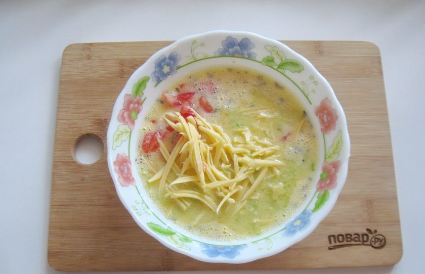 1. Этап. Омлет с сыром и кабачком: Добавьте тертый сыр, перемешайте.