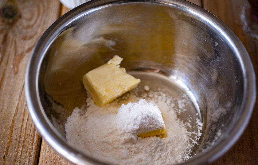 1. Этап. Шоколадное треснутое печенье: В отдельной миске соедините мягкое сливочное масло и 100 грамм сахарной пудры, аккуратно перемешайте миксером на небольшой скорости и уже только тогда взбейте в кремообразную массу.