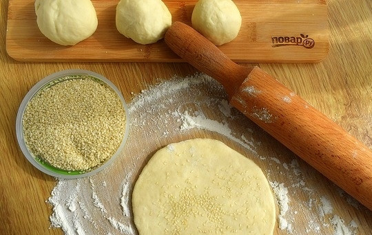 1. Этап. Бхатури: Присыпьте рабочую поверхность мукой. Разделите тесто на 8 равных частей, скатайте в шарики. Раскатайте каждый в лепешку диаметром 15 см. Посыпьте кунжутом, прокатайте слегка скалкой.