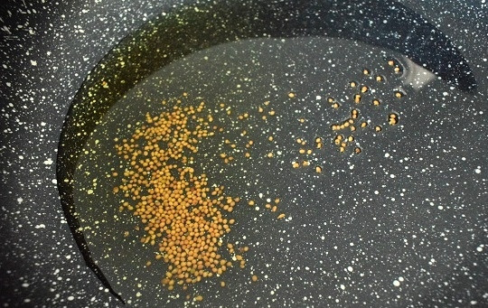 1. Этап. Салат с гренками и сыром: Масло растительное и семена горчицы нагрейте на сковороде. Как только семена горчицы станут лопаться, снимите с огня немедленно! Перелейте горячее масло в емкость для заправки.