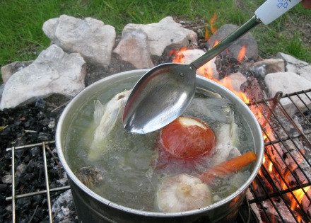 1. Этап. Уха на природе: В котелок положите неочищенный репчатый лук, головку чеснока, целую морковь, соль и перец. Пусть бульон кипит не менее 40 минут.