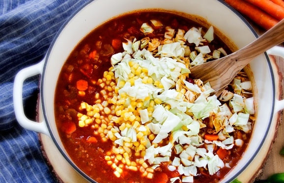 1. Этап. Итальянский обед: 3. Спустя необходимое время добавьте в кастрюлю свежую кукурузу, измельченную капусту, перемешайте и варите до готовности.