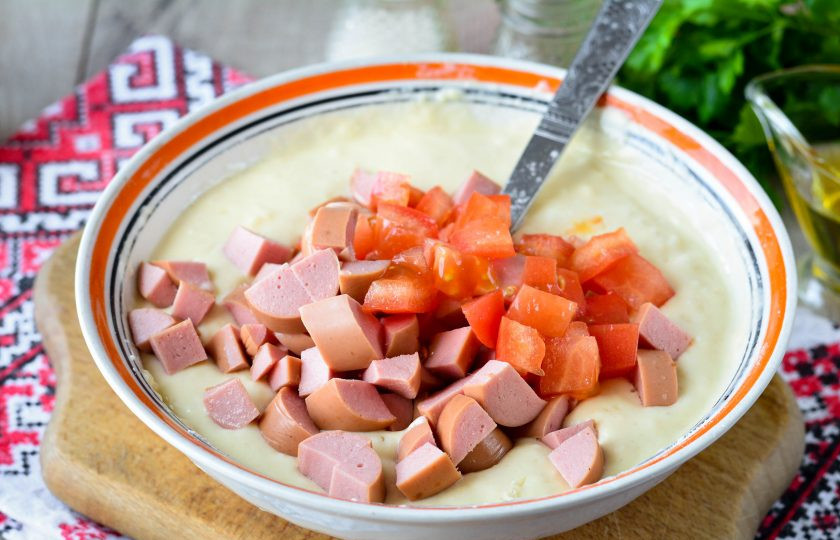 1. Этап. Оладьи-пиццы на молоке: Добавьте в тесто нарезанные кубиками сосиски и помидоры.