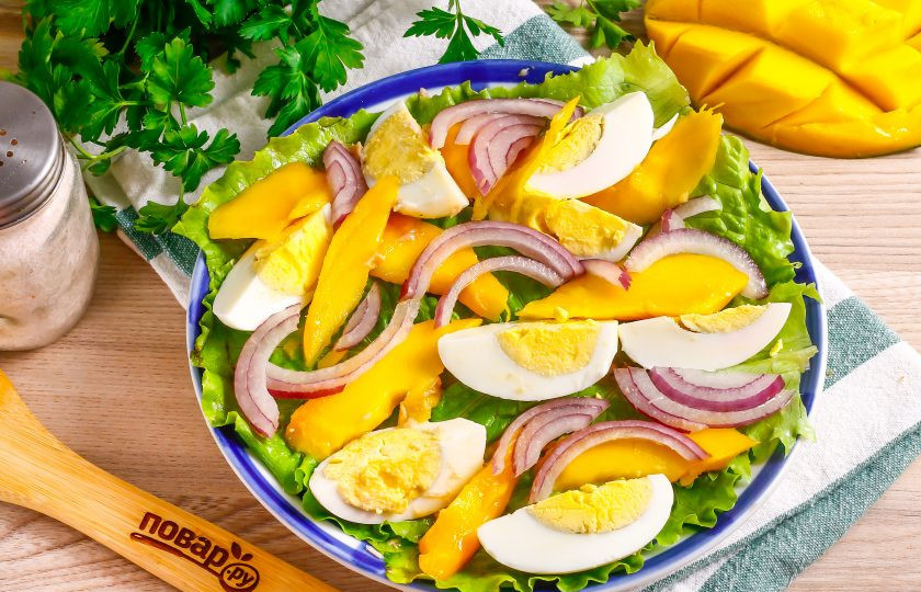 1. Этап. Салат с тунцом и манго: Половину красной луковицы промойте и нарежьте полукольцами, выложите между манго и яичной нарезкой.