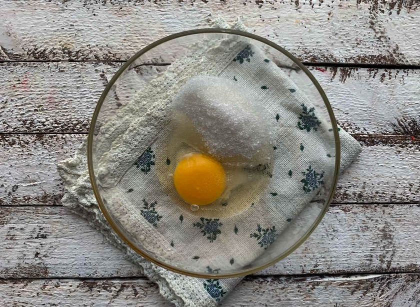 1. Этап. Кексы с повидлом: В глубокую тарелку вбейте яйцо, добавьте сахар, взбейте до появления пены.