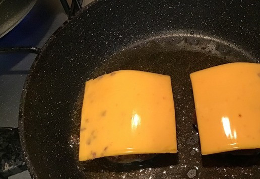 1. Этап. Чизбургер с карамелизированным луком: В разогретую сковороду добавить 1 ст. л. оливкового масла масло и обжарить бургеры с одной стороны. У меня бургеры покупные (полуфабрикат). Перевернуть, накрыть ломтиком сыра и обжарить с другой стороны. Я использовала ломтики Гриль Чиз от ТМ Hochland.