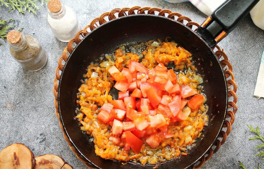 1. Этап. Щи из молодой капусты с курицей: В сковороду налейте растительное масло, выложите нарезанный репчатый лук, тертую на средней терке морковь и обжаривайте на среднем огне в течение 4-5 минут, перемешивая. Затем добавьте порезанный кубиком помидор и обжаривайте еще 3 минуты.