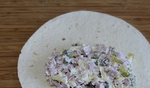 1. Этап. Горячий ролл с сосиской: Выложить половину начинки на лепешку.