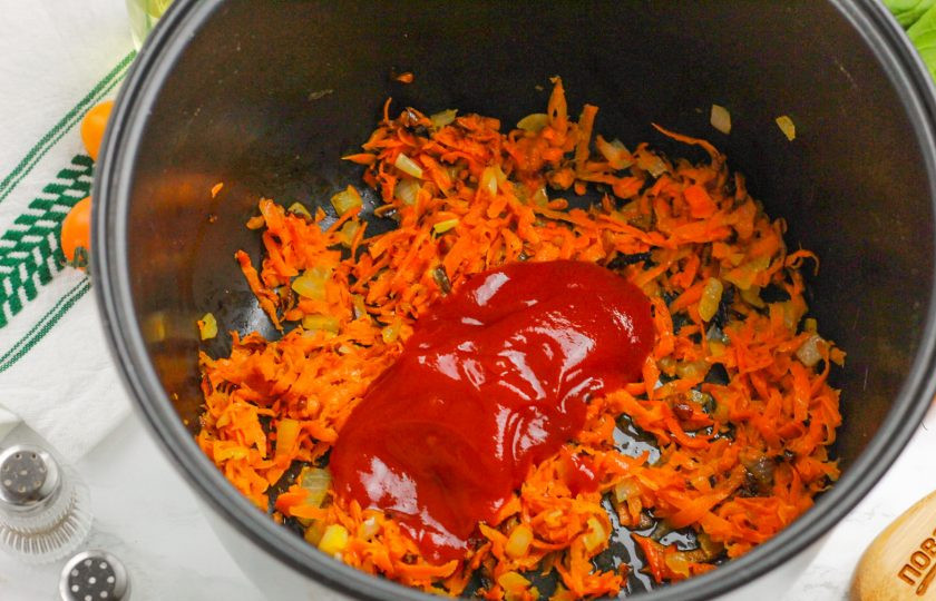1. Этап. Замороженные фаршированные перцы в мультиварке: Выложите в емкость томатную пасту, перемешайте и обжарьте 1-2 минуты.