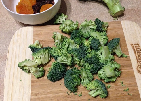 1. Этап. Салат из брокколи с курагой, изюмом и орехами: 1. Первым делом займемся брокколи. Отрезаем соцветия и разрежем их на небольшие кусочки.