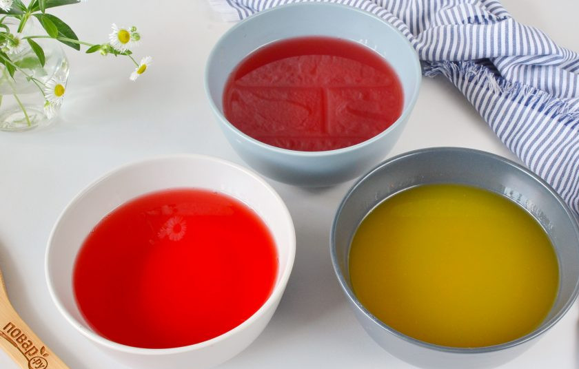 1. Этап. Желейный торт: Первым делом нужно сделать цветное желе. Вскипятите 900 мл. воды, залейте каждое желе 300 мл. воды, перемешайте и охладите в холодильнике до полного крепкого застывания (примерно 2 часа). Если на пакетике написано добавить 400 мл. воды — добавьте 300 мл., чтобы желе было плотным.