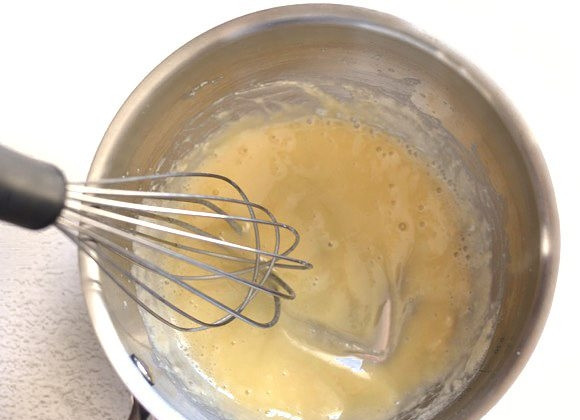 1. Этап. Сырный соус за 5 минут: 2. Отправьте сотейник на огонь и варите до растворения масла, энергично перемешивая венчиком. Взбивайте около 1 минуты.