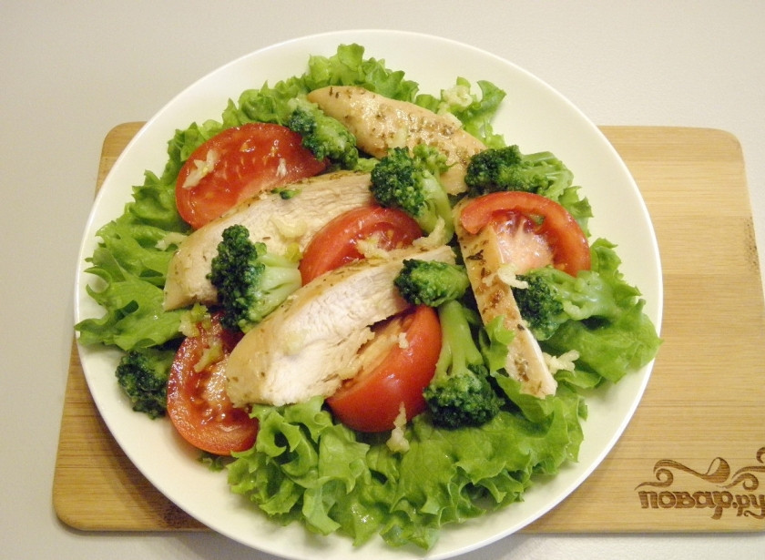 1. Этап. Салат с брокколи и курицей: Разложите на листьях жаренное мясо (порезанное длинными кусочками), помидоры и брокколи. Раздавите чеснок через пресс и распределите по салату. Посолите, приправьте травами.