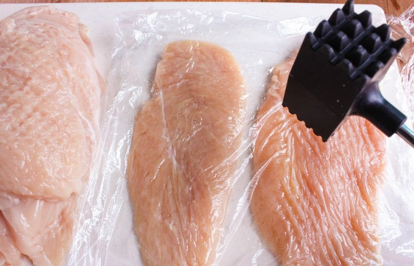 1. Этап. Куриные отбивные в панировке: 1. Вымойте куриное филе и разрежьте вдоль на 2 части. Выложите все на разделочную доску, накройте пленкой и слегка отбейте молоточком.