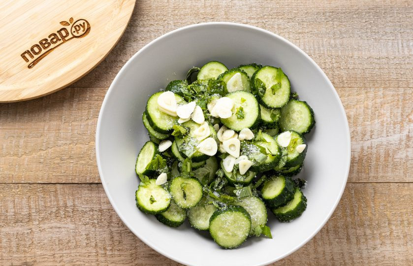 1. Этап. Салат из огурцов с базиликом на зиму: Добавьте нарезанный базилик, чеснок и сахар. Перемешайте.