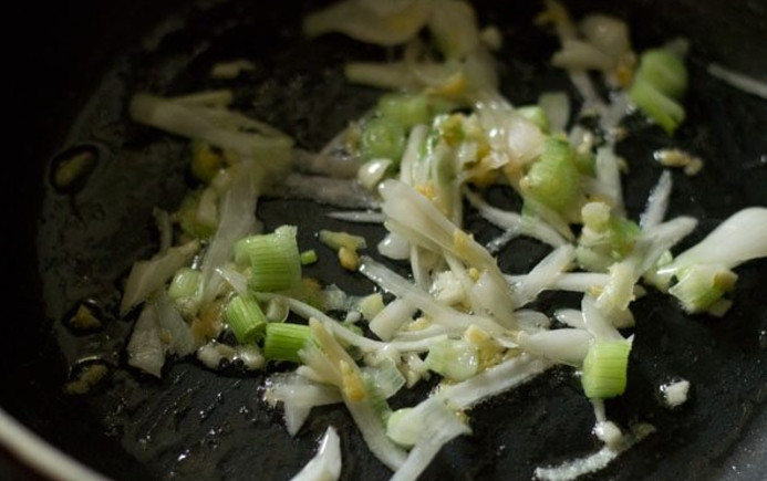 1. Этап. Рецепт супа с грибами: Сперва порежьте все ингредиенты. Измельчите лук, отделите зеленую часть от белой, грибы порежьте пластинками. На масле обжарьте чеснок, затем добавьте белую часть лука и жарьте до прозрачности.