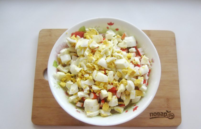 1. Этап. Салат Столичный с крабовыми палочками: Яйца сварите вкрутую, охладите и очистите. Мелко нарежьте.