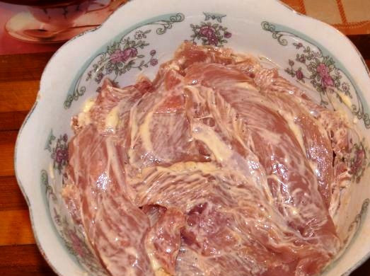 1. Этап. Запеченная грудка с грибами: Порежьте курятину тонкими пластинками. Смешайте майонез с перцем и солью, и замаринуйте мясо в этой смеси на 20 минут.