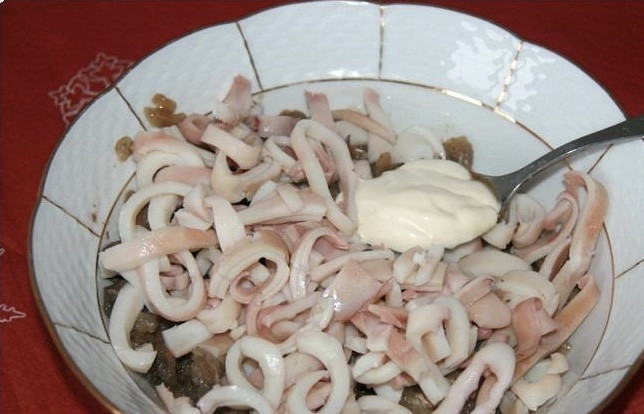 1. Этап. Салат из кальмаров и шампиньонов: 8. В миске смешиваем кальмары, майонез и чеснок, продавленный через пресс, а также жареный лук.