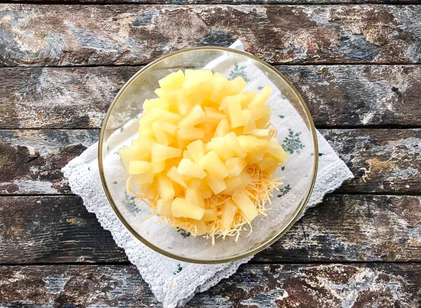 1. Этап. Тарталетки с сыром, ананасом и чесноком: К сыру добавьте нарезанные ананасы.