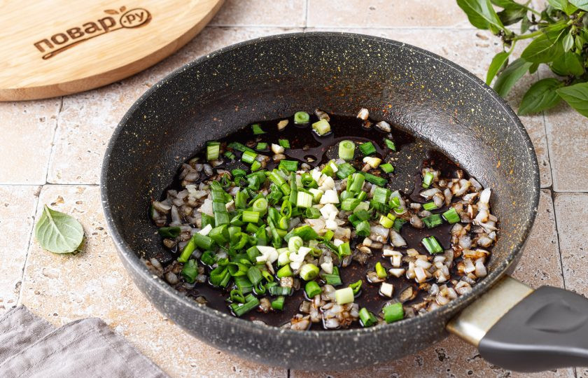 1. Этап. Булгур с соевым соусом: Добавьте порезанный чеснок и зеленый лук, влейте соевый соус. Готовьте еще 2-3 минуты.