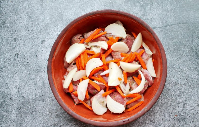 1. Этап. Оленина с картошкой в духовке: В форму для запекания выложите оленину. Морковь порежьте крупной соломкой, репчатый лук крупными дольками и выложите поверх мяса.