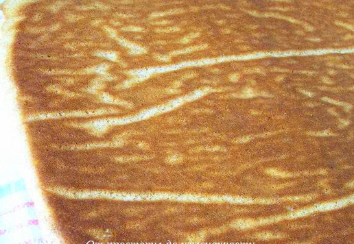 1. Этап. Рулет на сгущёнке с миндалём: Переверните на рабочую поверхность, накрыв кухонным полотенцем, снимите бумагу для выпечки, снова приложите её к бисквиту.