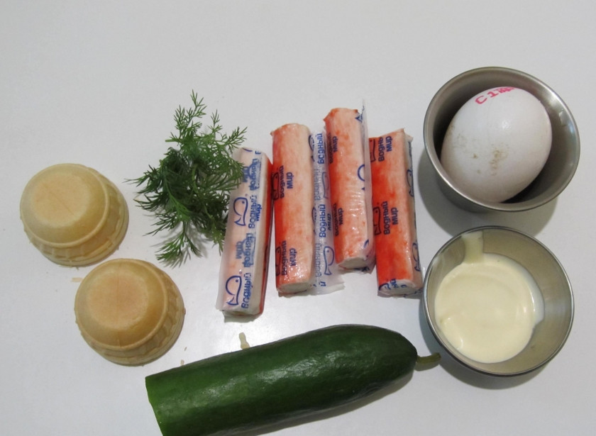 1. Этап. Тарталетки с крабовыми палочками и огурцом: 1. Если вы хотите приготовить быструю и вкусную закуску на праздничный стол или фуршет - тарталетки с крабовыми палочками и огурцом придутся как раз кстати. Их основа - салат из крабовых палочек, которым и будут начиняться тарталетки.