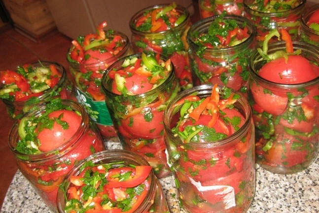 1. Этап. Солянка с помидорами: Часть помидоров (около одного килограмма) пропустите через мясорубку. Нам понадобится этот соус для заливки. Выложите овощи в банки и залейте их томатной заливкой.