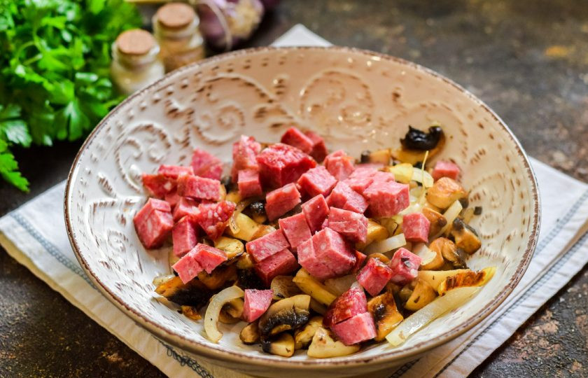 1. Этап. Салат Соренто: Переложите в салатник остывшие грибы с луком, колбасу.