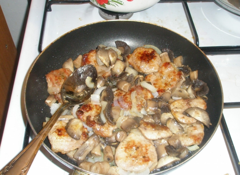 1. Этап. Телятина с грибами в сметане: Добавьте к луку порезанные грибы и обжаренное мясо. Влейте немного воды и тушите под крышкой 15 минут.