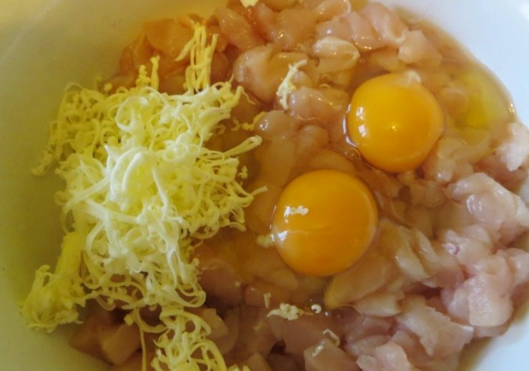 1. Этап. Куриные котлеты Нежность: В нарезанное филе разбиваем яйца и добавляем тертое на мелкой терке сливочное масло, перемешиваем все ингредиенты.