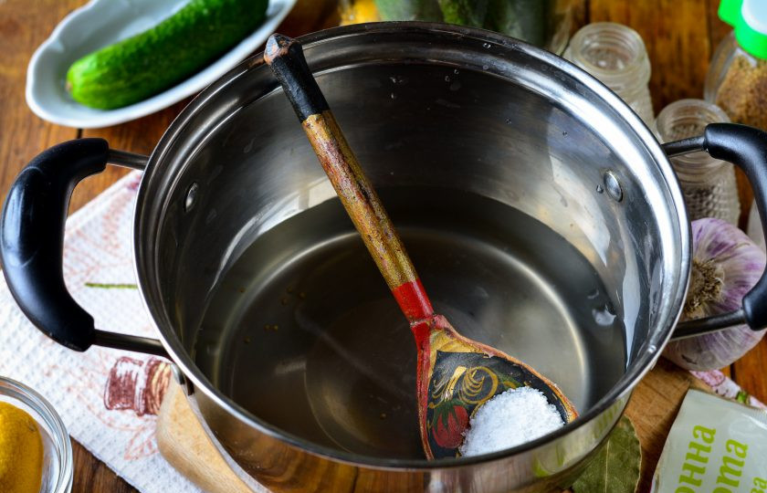 1. Этап. Огурцы с лимоном на зиму: Воду слейте в кастрюлю, всыпьте соль, сахар и лимонную кислоту. Закипятите маринад.