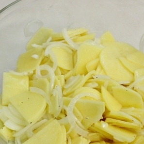 1. Этап. Испанская тортилья: 2. Луковицу очистите и нарежьте тонкими полукольцами. К картофелю добавьте нарезанный лук, 3-4 ст. ложки оливкового масла, соль и черный перец. Хорошенько все перемешайте.