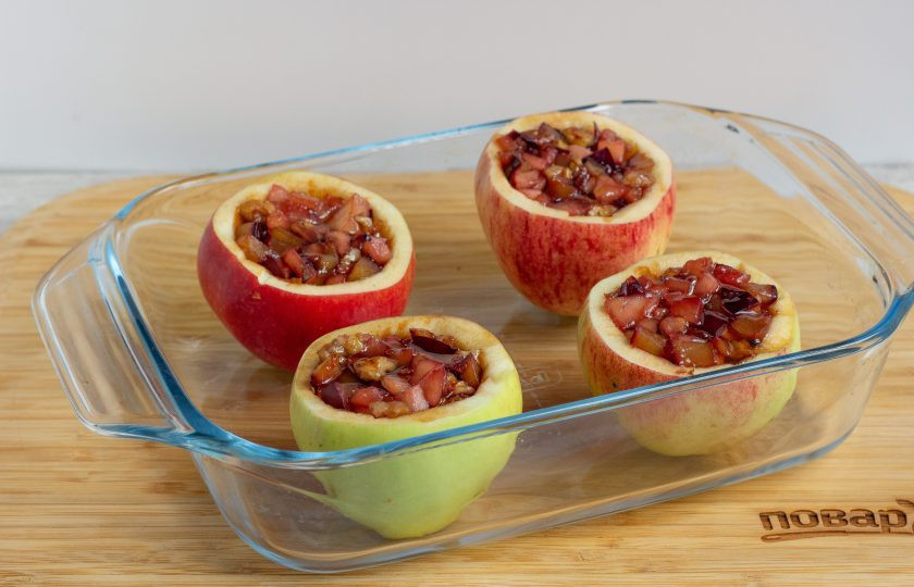 1. Этап. Яблоки, фаршированные карамелизированной сливой: Поставьте яблоки в форму для запекания и наполните начинкой. Полейте каждое яблоко буквально 0,5 ч. л. меда, для аромата.