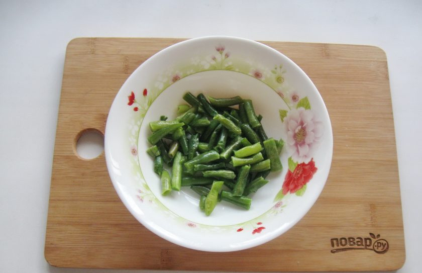 1. Этап. Постный салат с сухариками: Спаржевую зеленую фасоль помойте и отварите до мягкости. Выложите в салатник.