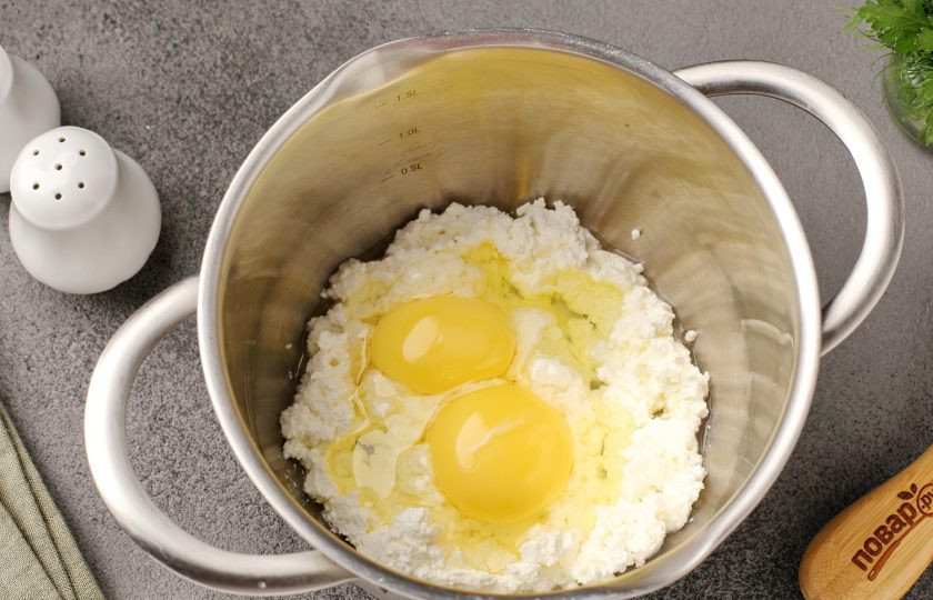 1. Этап. Творожные лепёшки с сыром и зеленью: Соедините творог и яйца. Перемешайте.