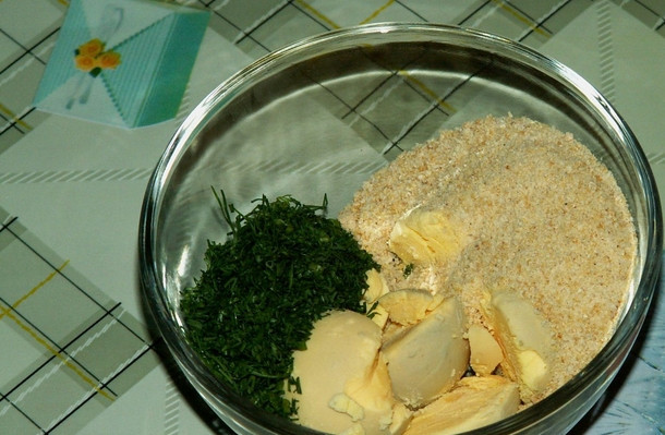 1. Этап. Салат с рыбными консервами: Желтки соединяем с измельченным укропом и панировочными сухарями. Разминаем вилкой до однородности.