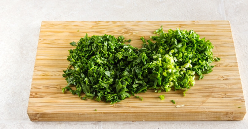 1. Этап. Капустный пирог на сметане и сливках: 2. Вымойте всю зелень (любую по вкусу), выложите на салфетку, а затем нарубите мелко. Добавьте зелень в сотейник к капусте, перемешайте и готовьте еще 3-5 минут, затем снимите с огня.