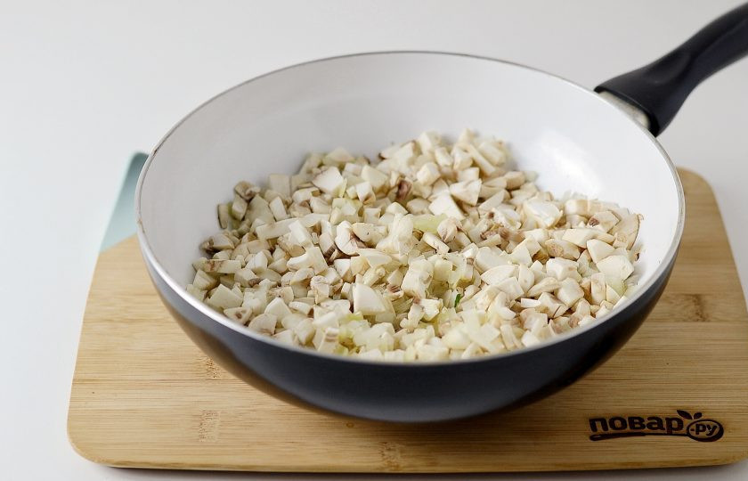 1. Этап. Запеканка с грибами: Лук и шампиньоны нарежьте на мелкие кубики и обжарьте в сковороде до испарения лишней жидкости. Посолите и поперчите по вкусу.